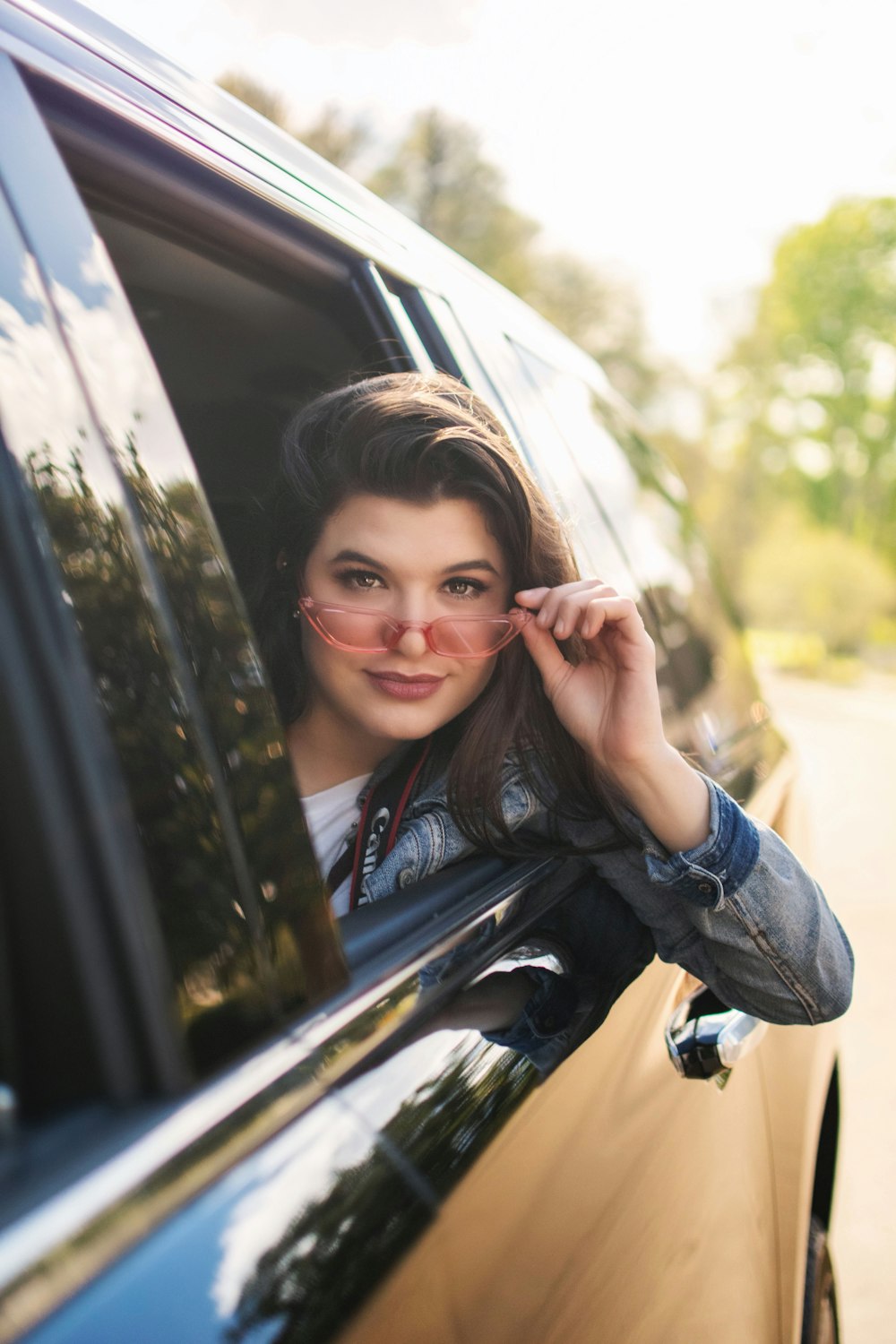 woman wearing blue denim jacket sitting inside vehicle