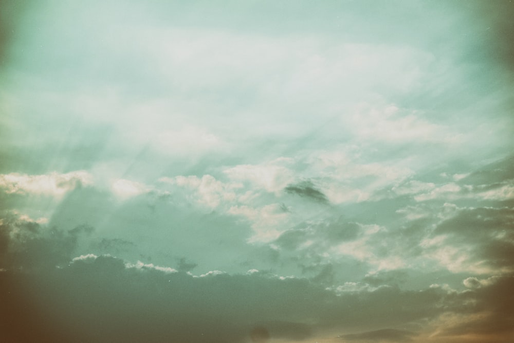 a plane flying through a cloudy sky