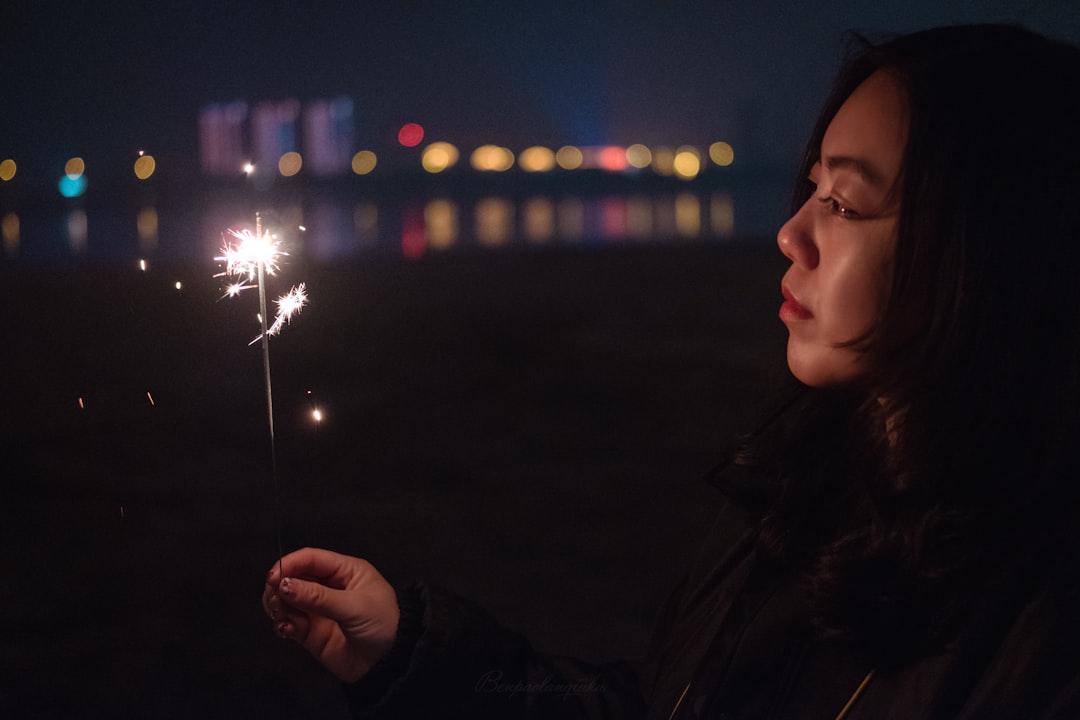 selective focus photography of woman holding sparkler