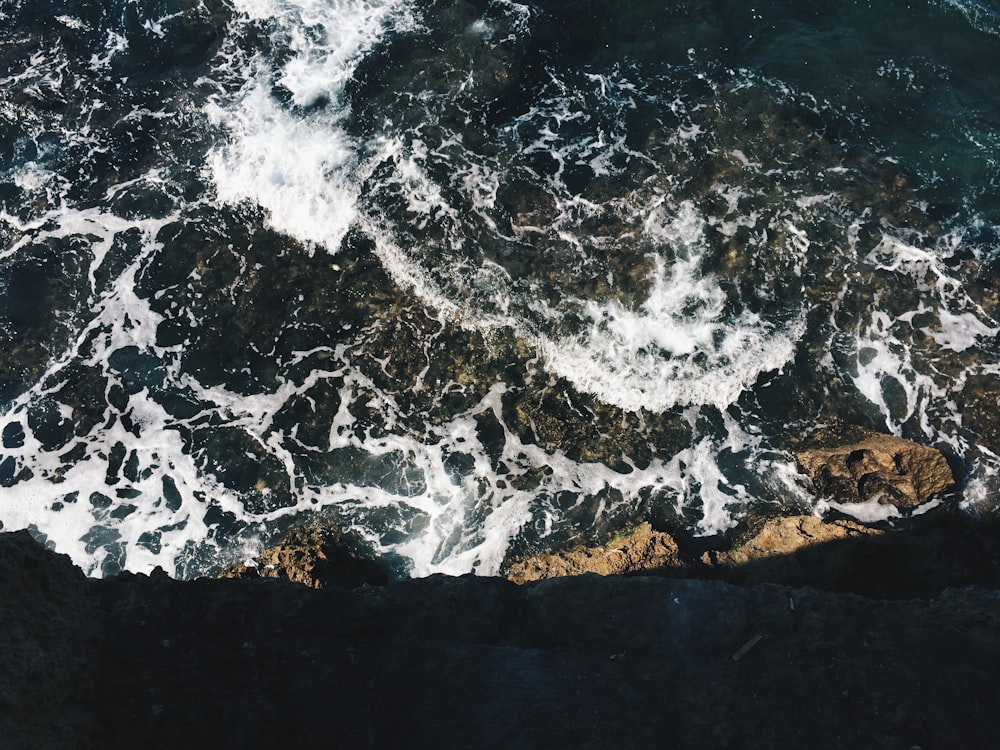 Foto di onde dell'oceano e litorale con rocce massicce marroni