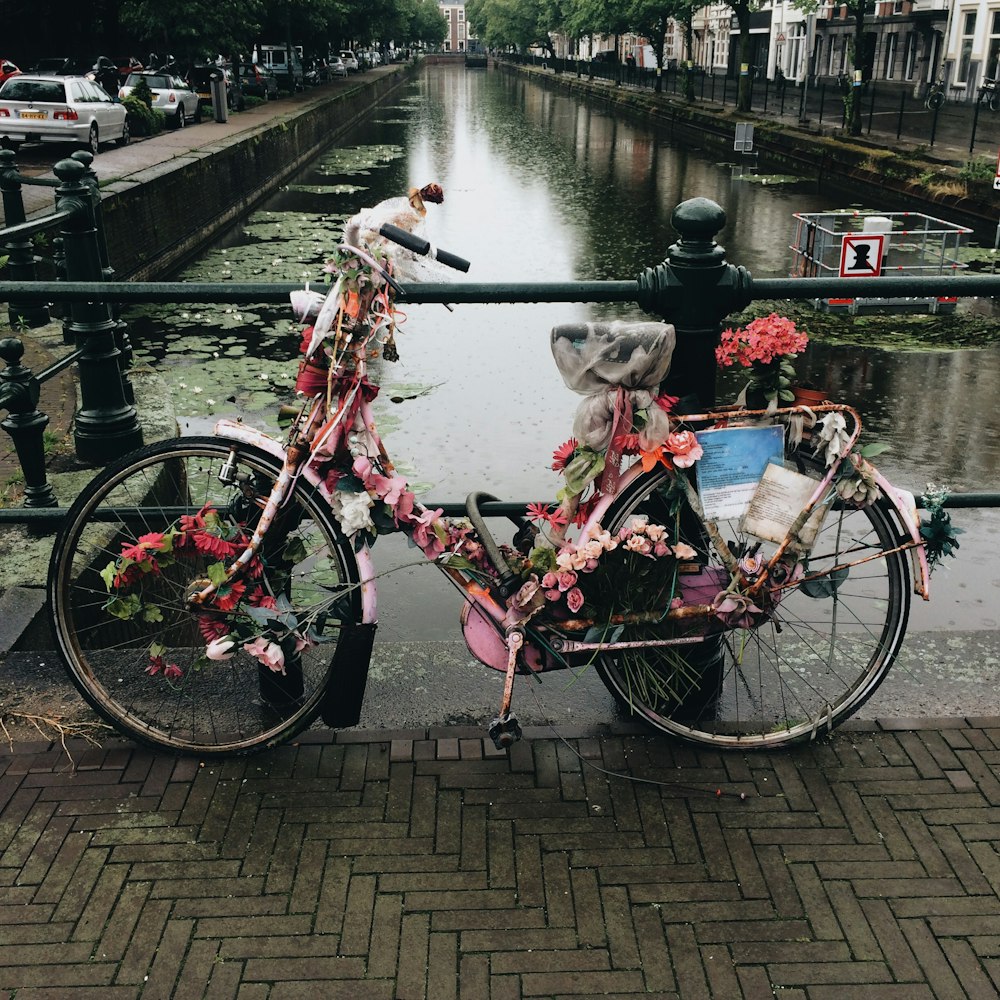 bike covered with flowers on bridge near pond
