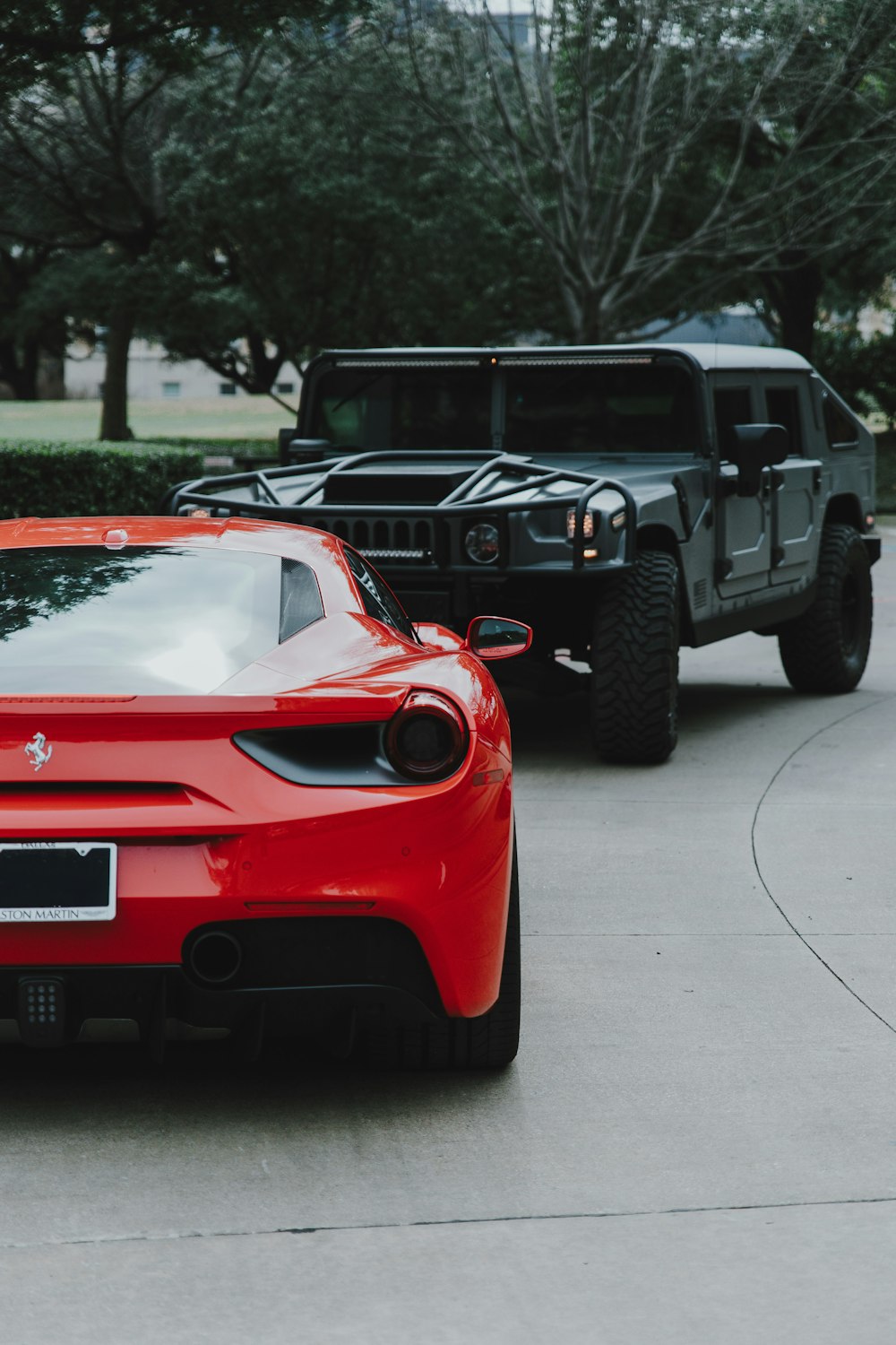 red Ferrari car and black Hummer SUV