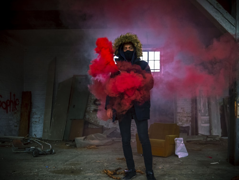 man in black coat with red smoke