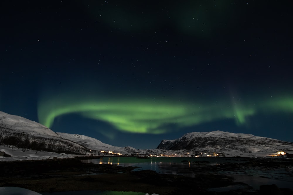 aurora borealis above mountain and body of water