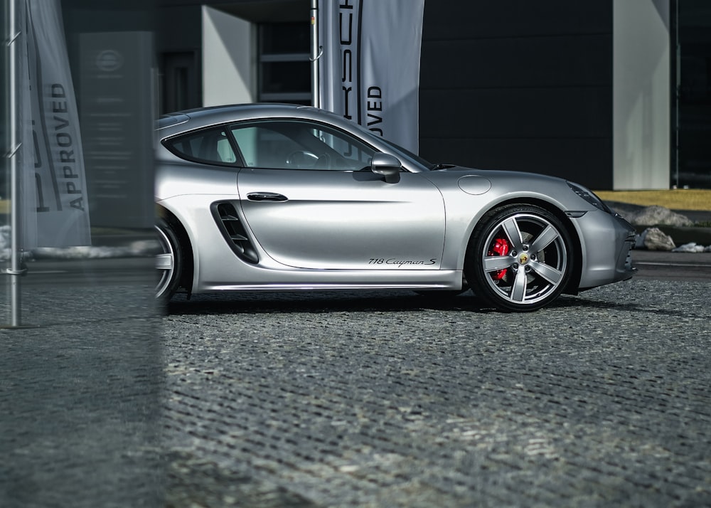 gray Porsche Carrera parked on gray pavement during daytime