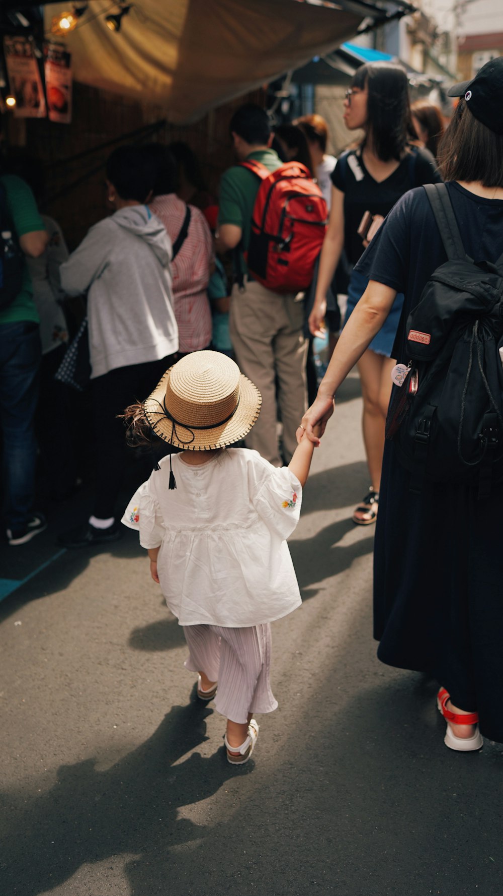 girl holding hands next to woman