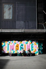 man and woman sitting on bench