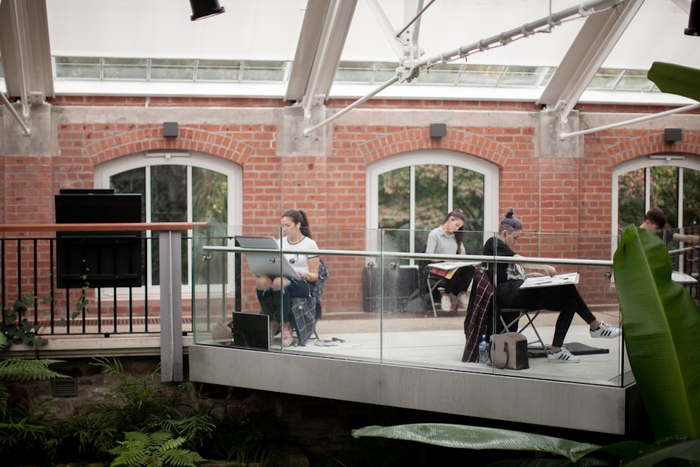 people painting inside a glass terrace