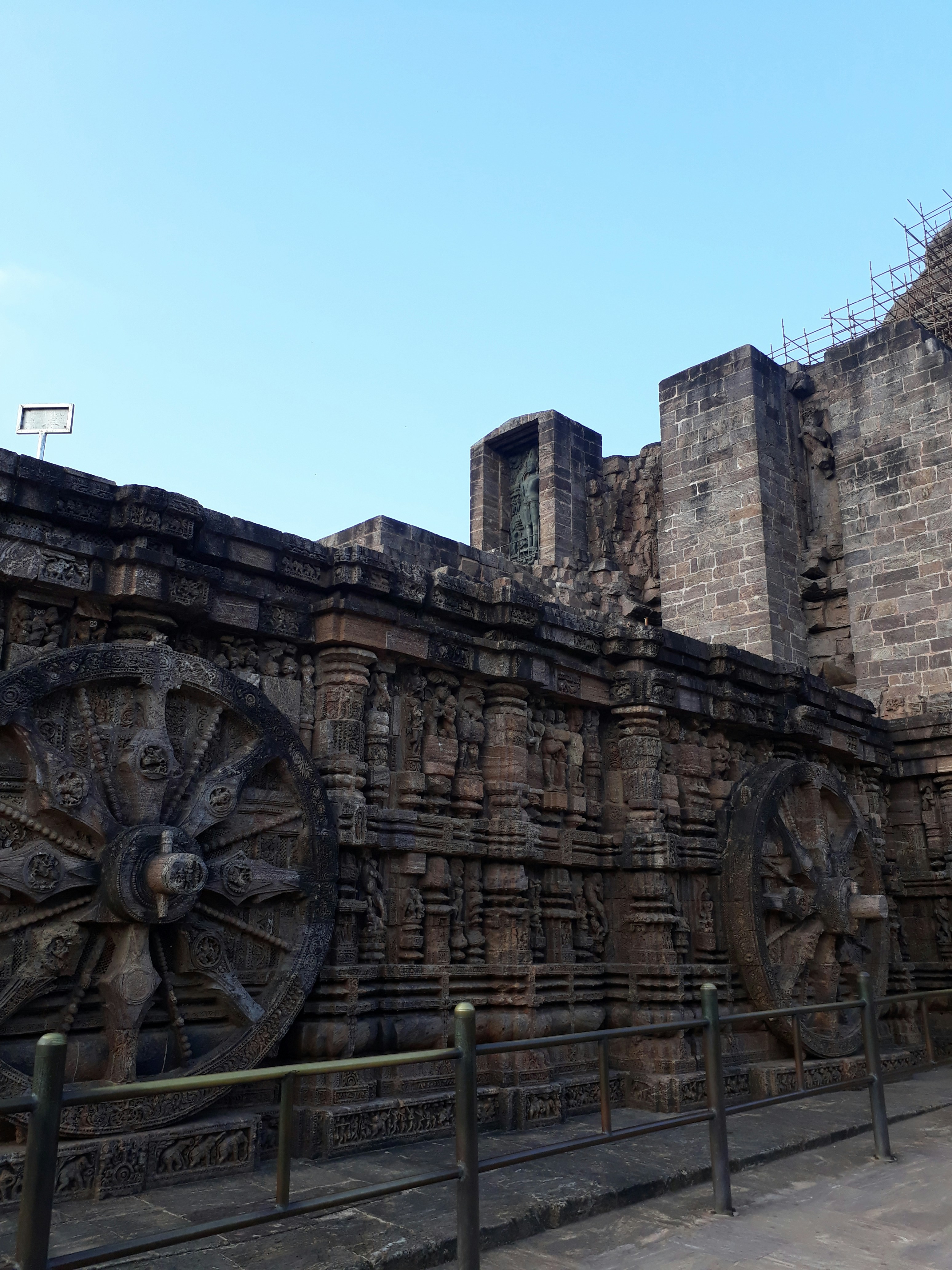 Ancient stone chariot at Vittala Temple in Hampi with orange boulders and clear sky
