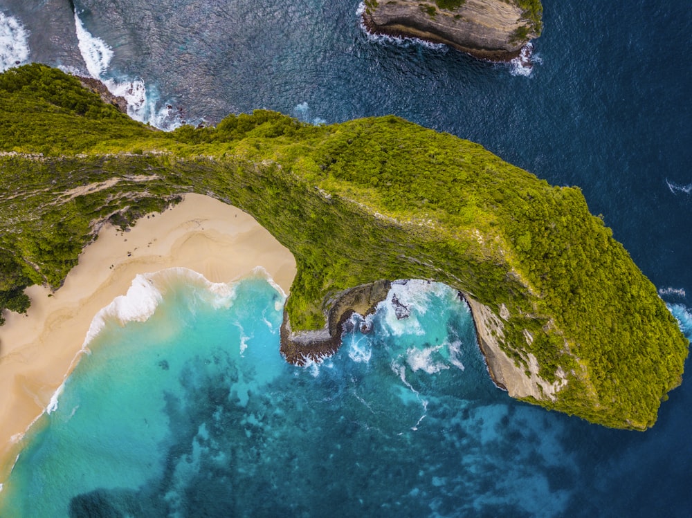 green mountain surrounded by body of water