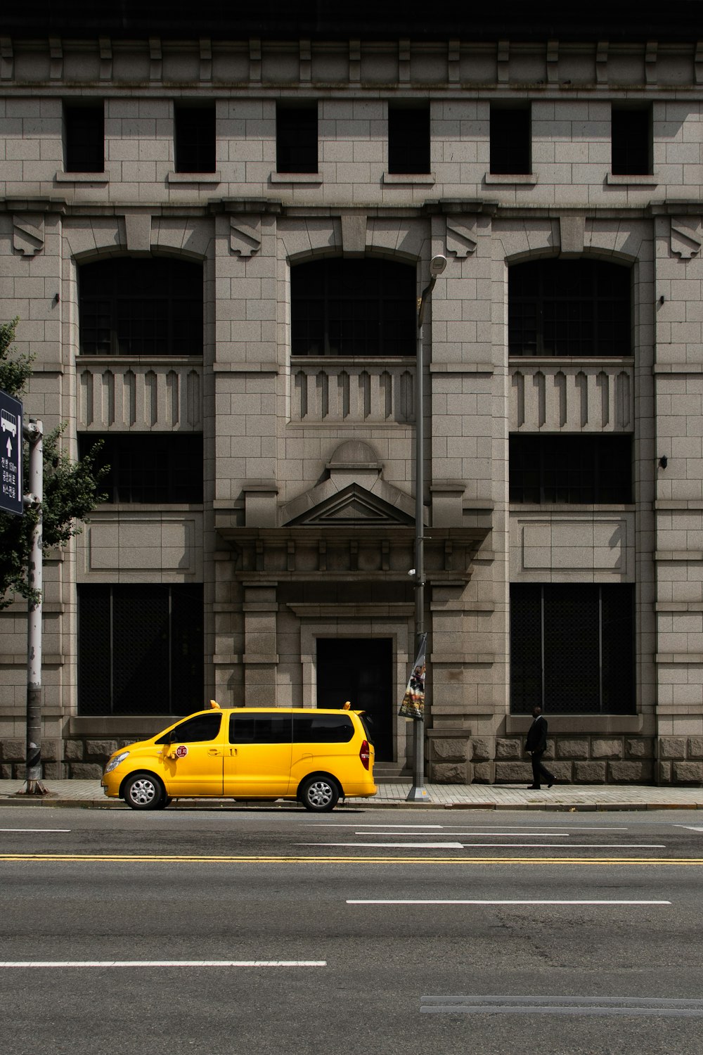 yellow vehicle on road beside building