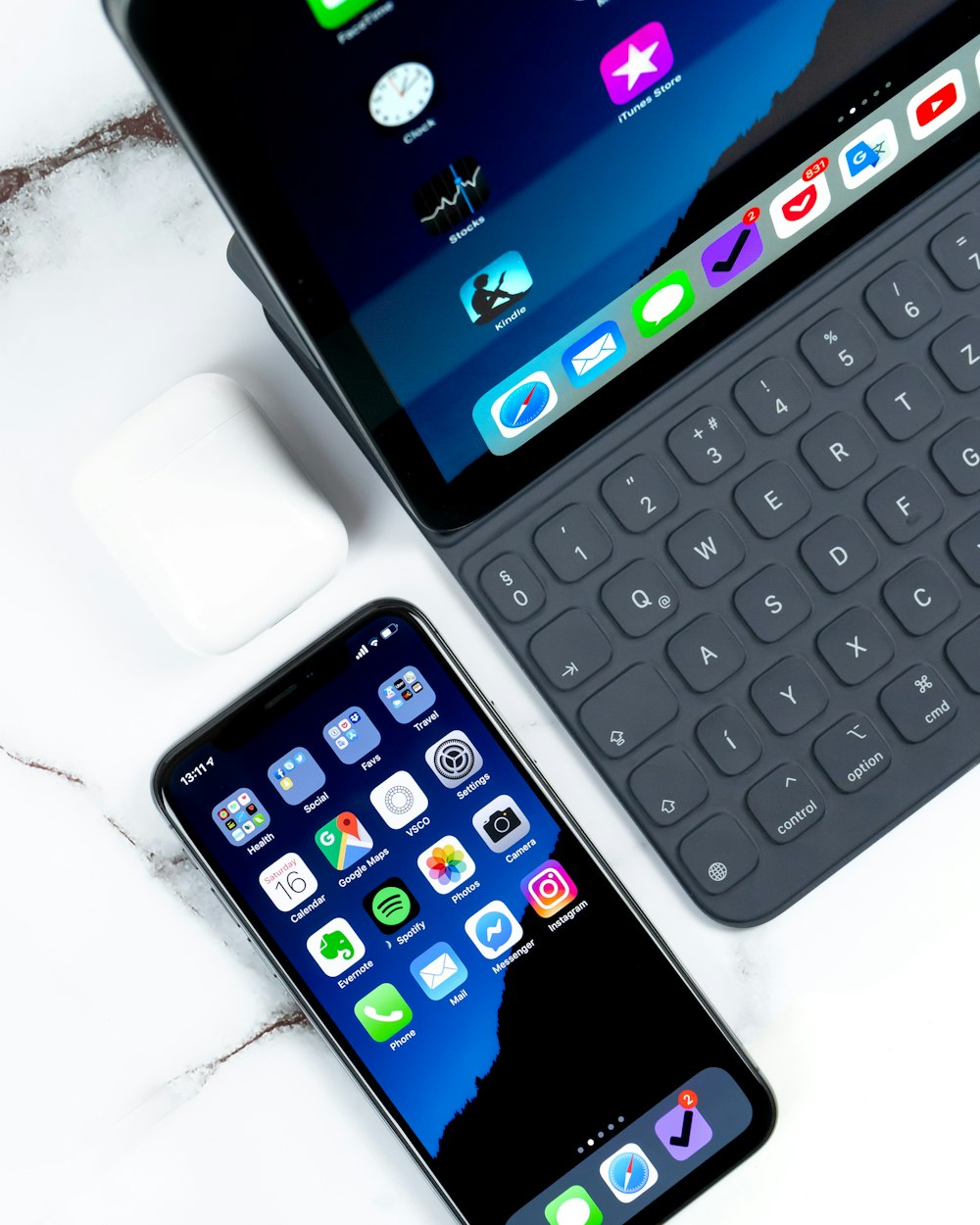 Smartphone noir près d’une tablette sur une surface blanche