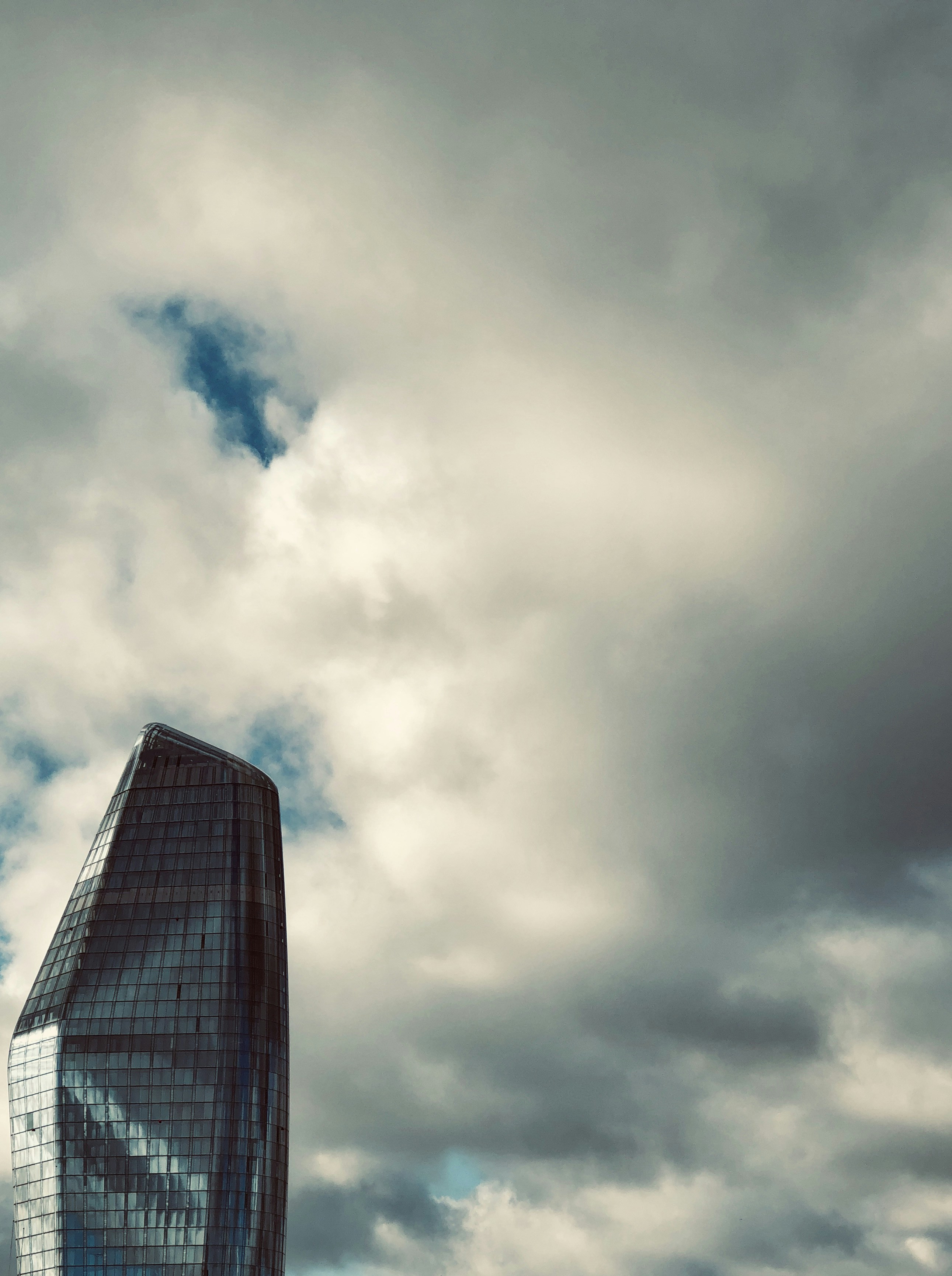 grey cloudy sky over glass paneled building