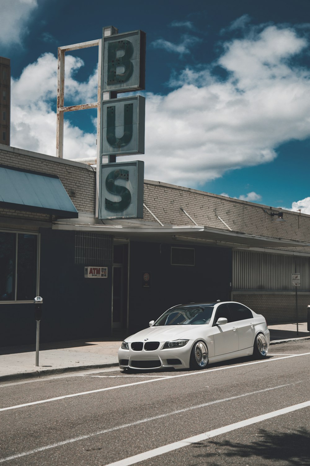 white BMW E90 sedan near Bus station