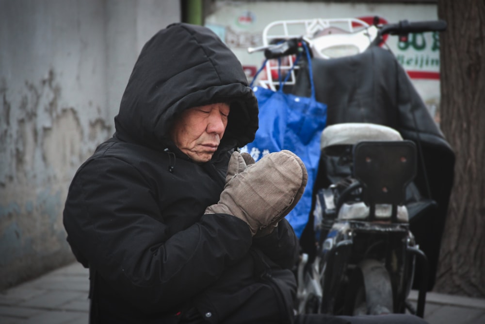 man in black coat praying on focus photography