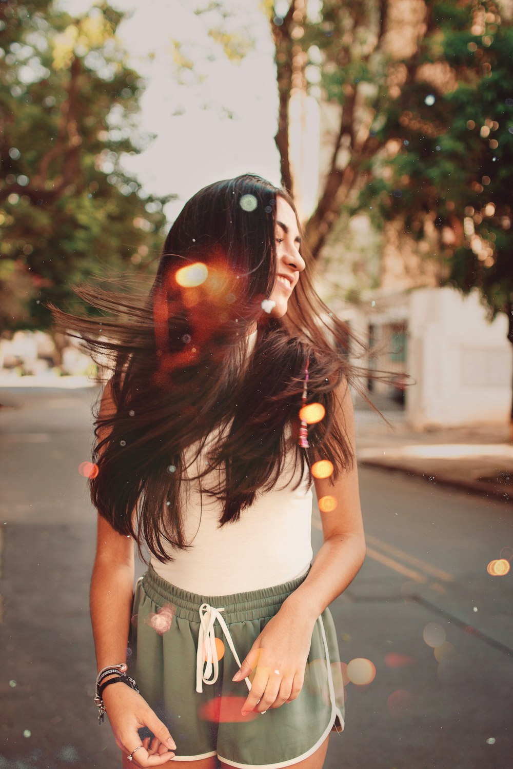 selective focus photography of woman standing on road while looking to her left