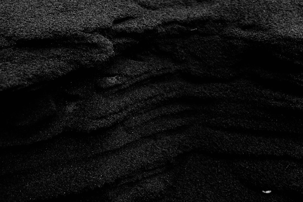 a black and white photo of sand and water