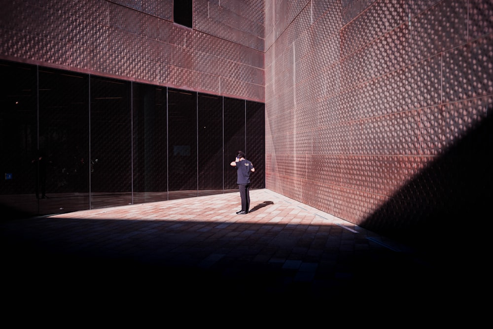 person standing between brown wall