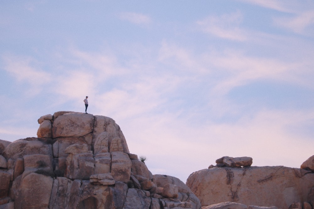 person standing on rock formation during daytime