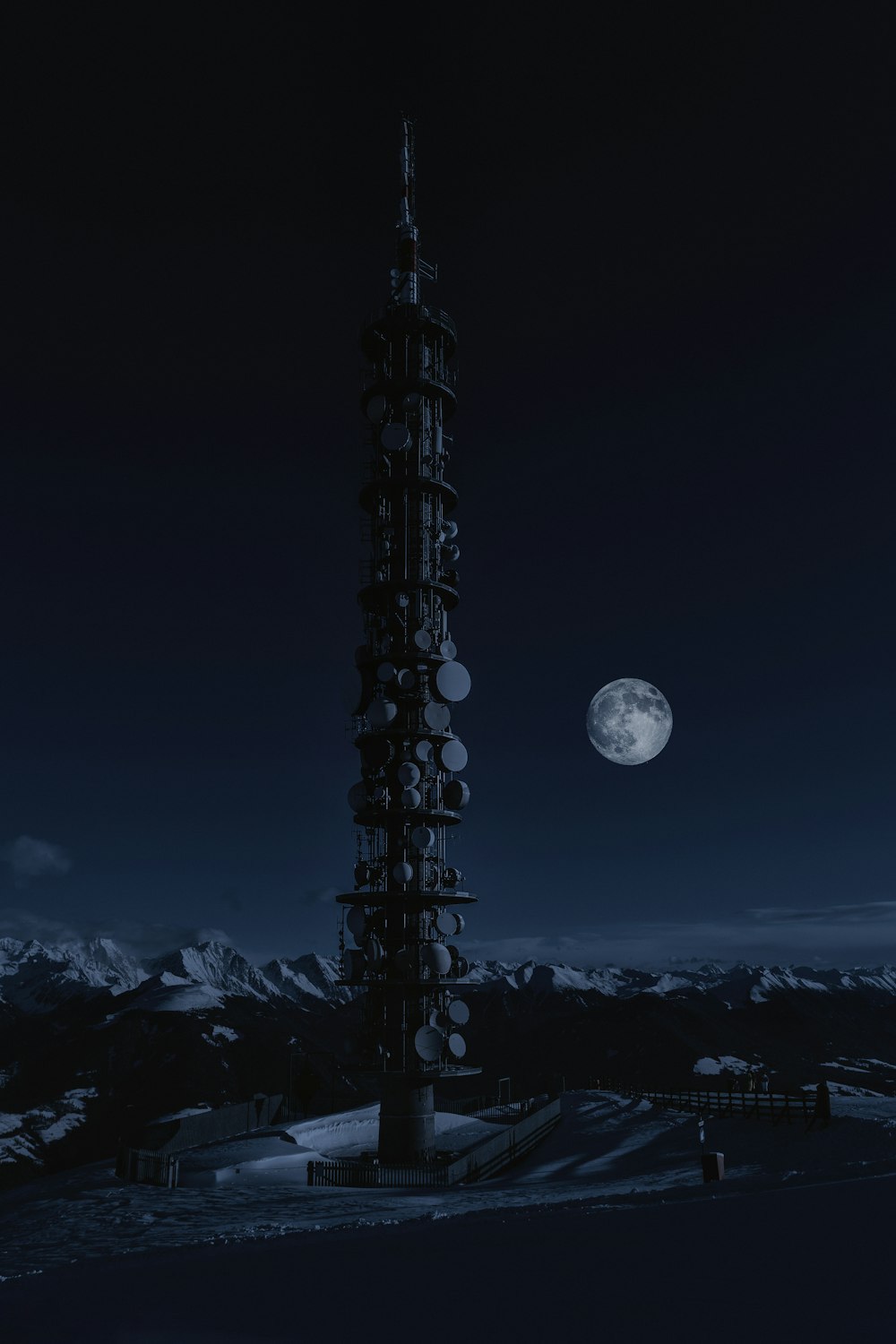 Torre en la nieve bajo la luna llena