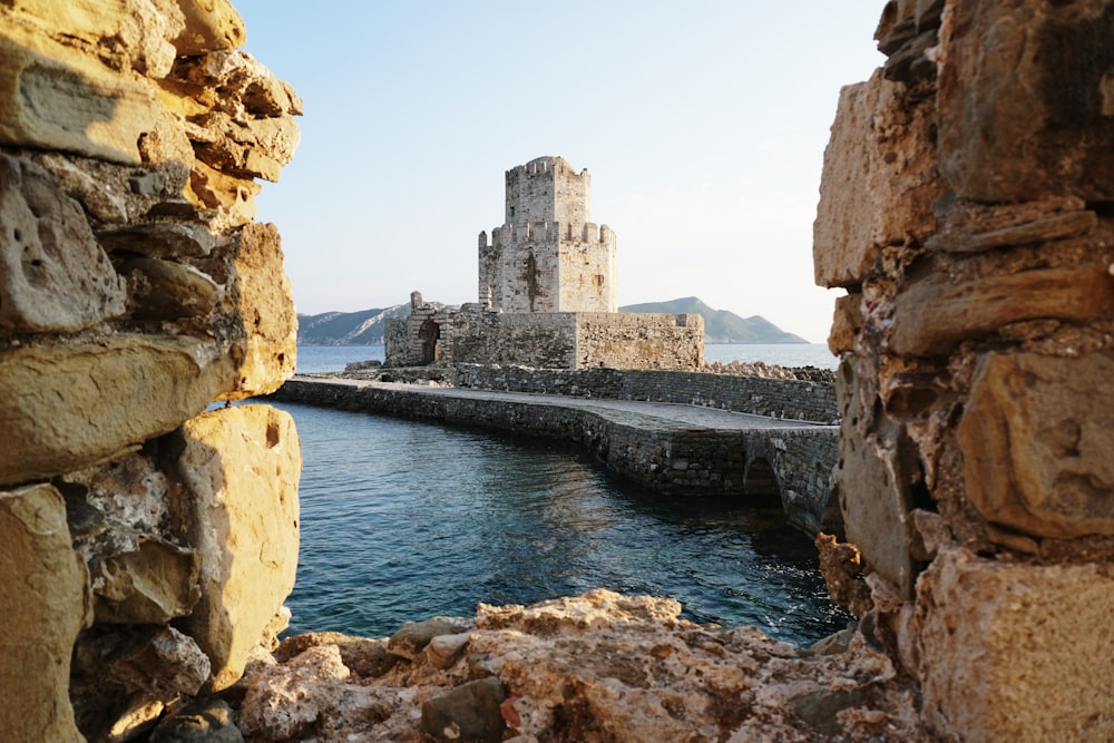 gray concrete structure beside body of water during daytime