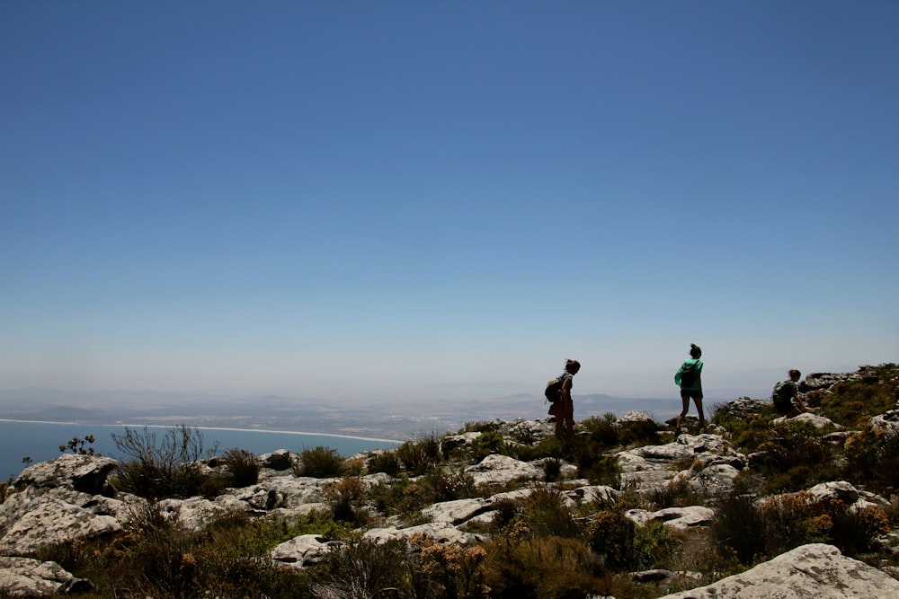 two people walking on rock formation at daytime