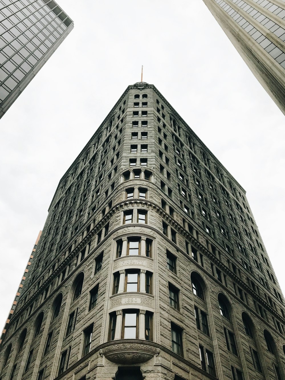 gray high-rise building beside other buildings during daytime