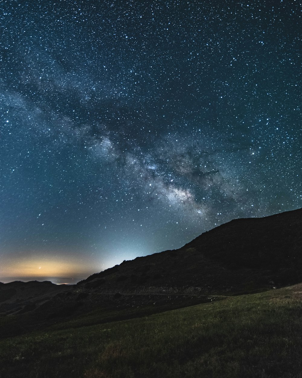 silhouette of mountain under starry sky