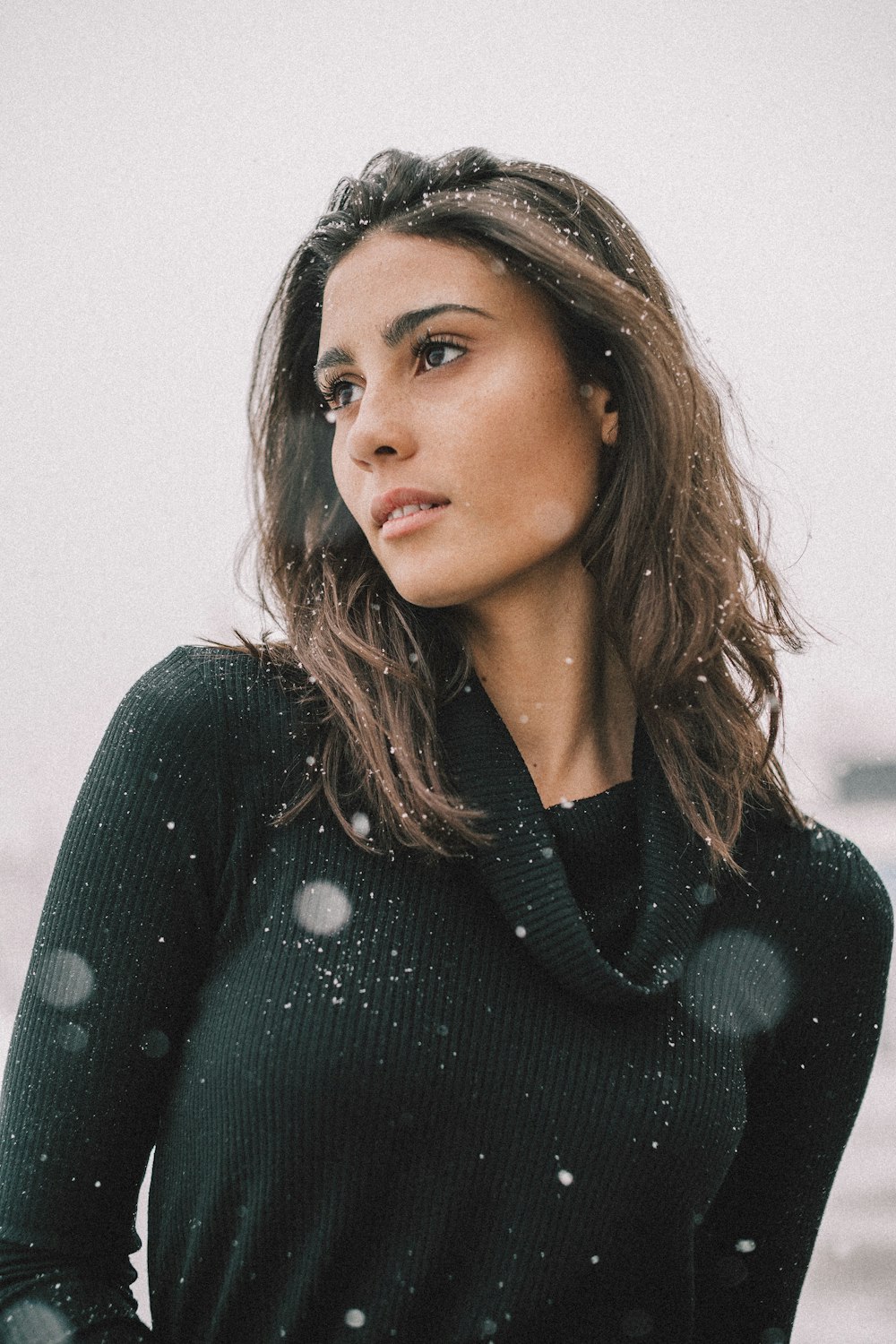 Femme portant une chemise noire à manches longues sur un champ de neige