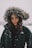 A model showcasing a trendy winter jacket against a backdrop of falling snowflakes.