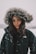 A model showcasing a trendy winter jacket against a backdrop of falling snowflakes.