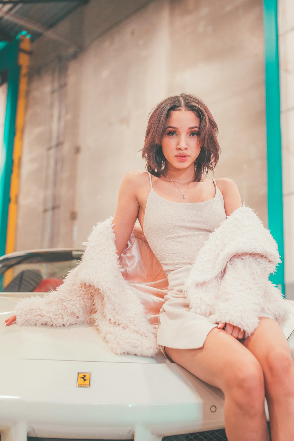 a woman sitting on top of a white car