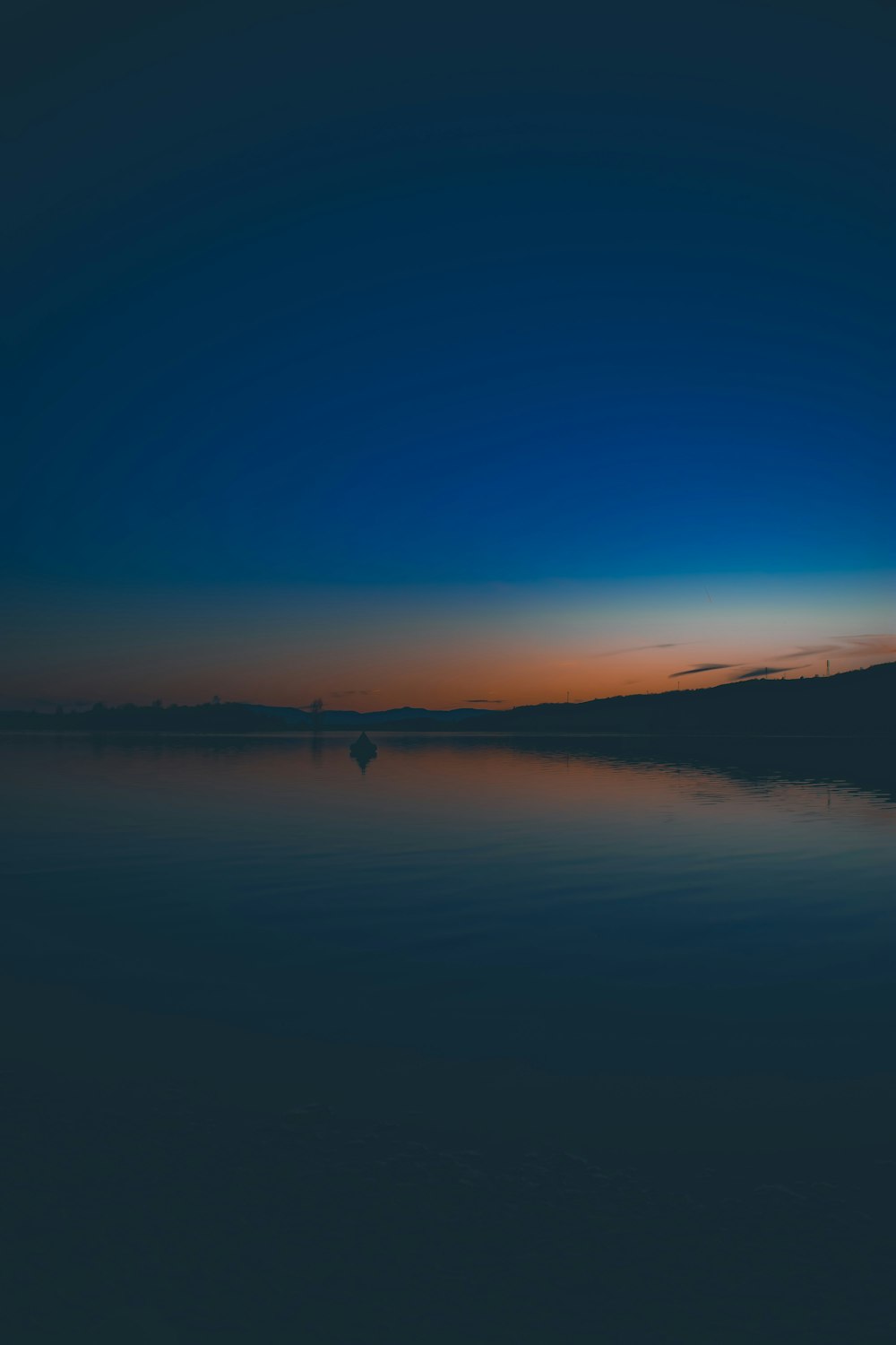 calm body of water under blue sky