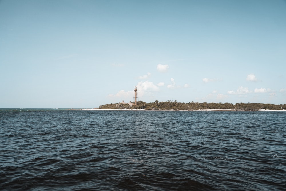 lighthouse on island under blue sky