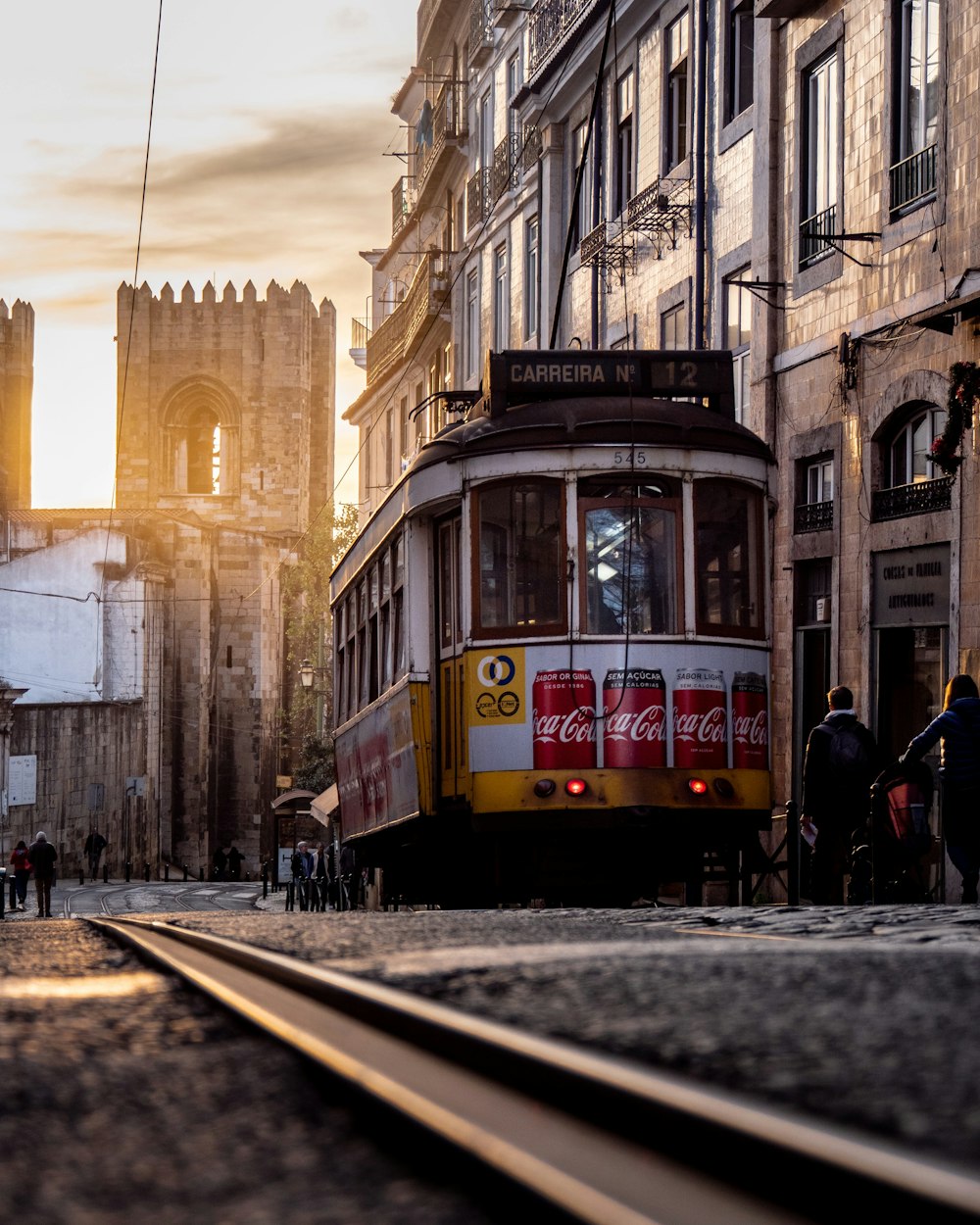 yellow and white tram on city beside building