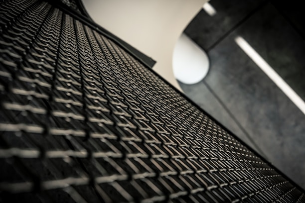 Close-up of a concrete fence panel being shaped using vibropress technology in a bright factory setting.