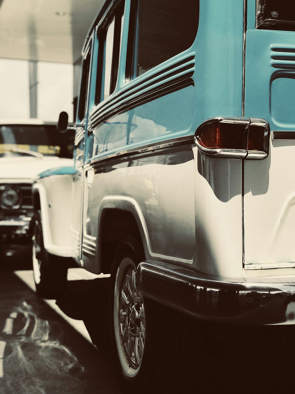 white and teal vehicle parked front of white vehicle