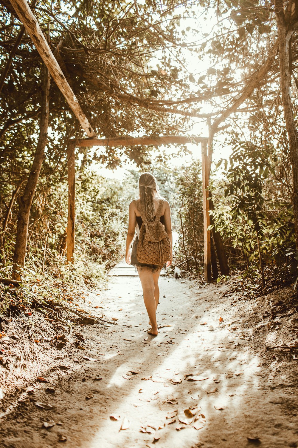woman standing on tree tunnel at daytime