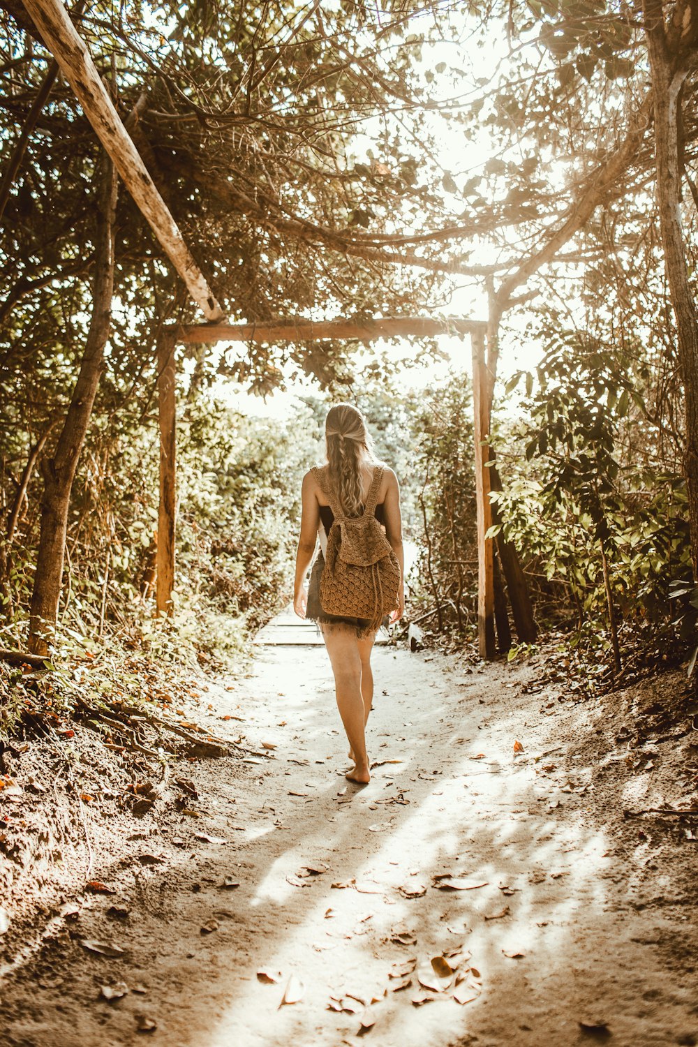 Mujer de pie en el túnel del árbol durante el día