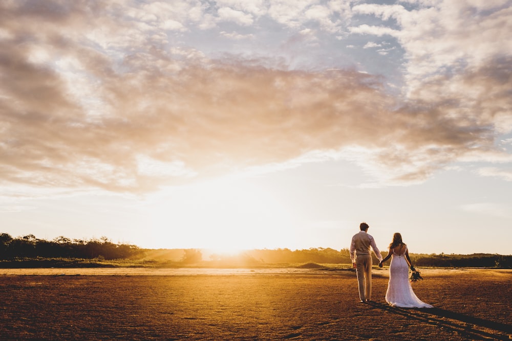 Casal em pé na estrada sob o pôr do sol