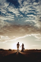 Couple holding hands during a sunset walk on the beach.