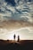 A happy couple walking hand in hand in a park during sunset.
