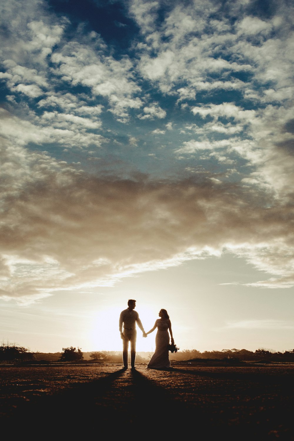silhouette photo of man and woman under clear blue sky