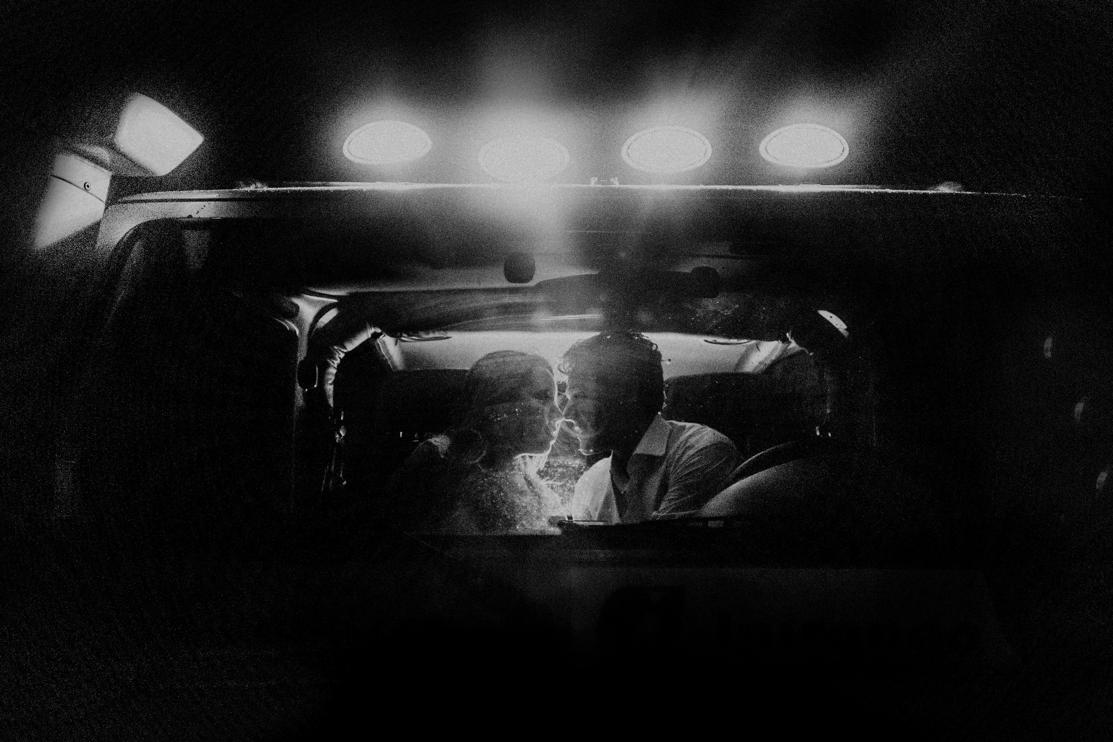 lighted kissing couple inside car