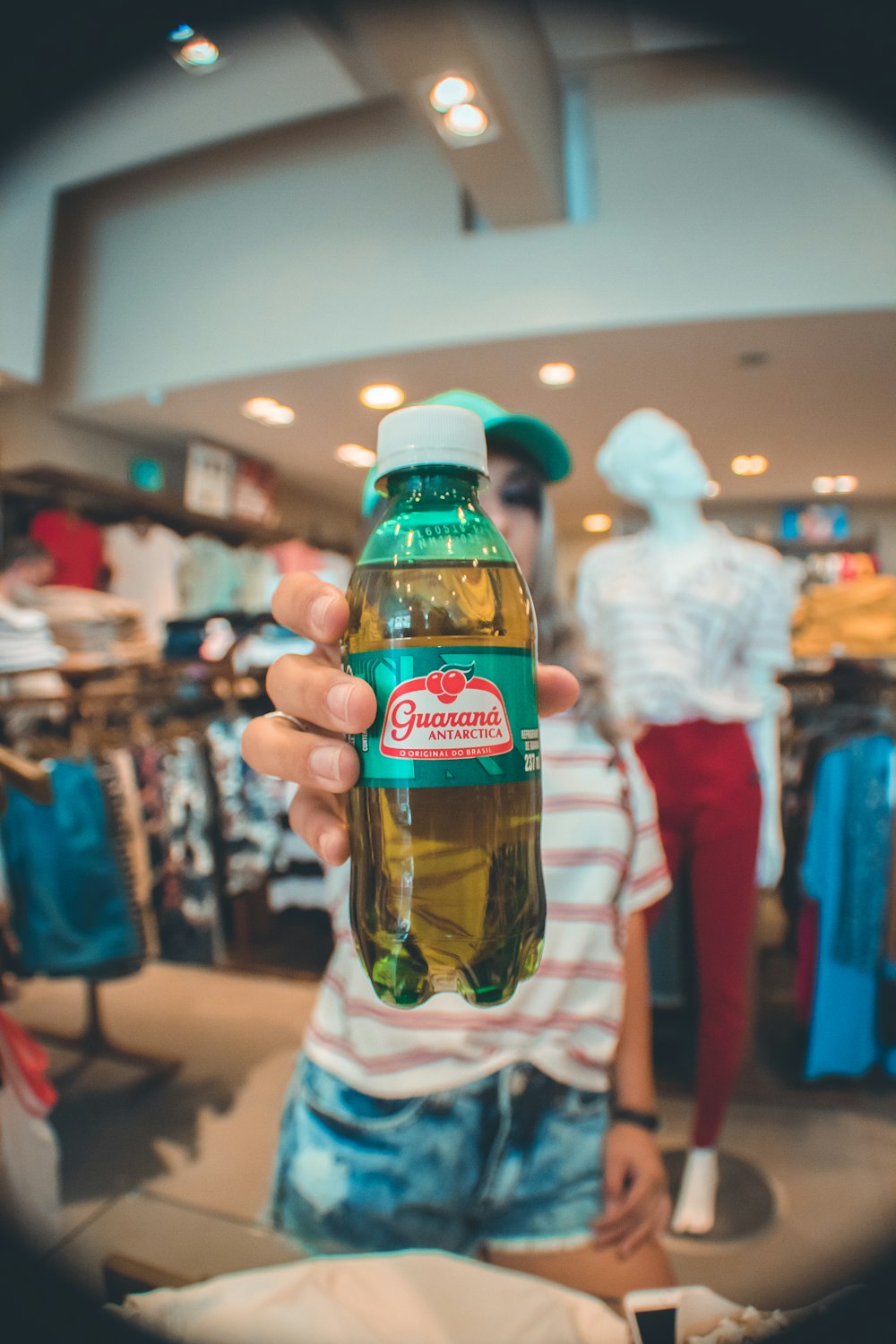 woman in striped shirt holding green labeled bottle