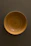Close-up of a handcrafted wooden bowl with natural grain patterns, glowing softly in warm light.