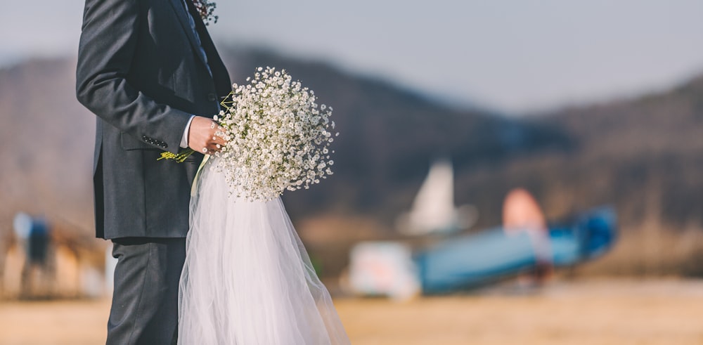 man holding white bouquet