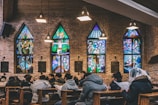 A group of parishioners praying together inside a warmly lit church.