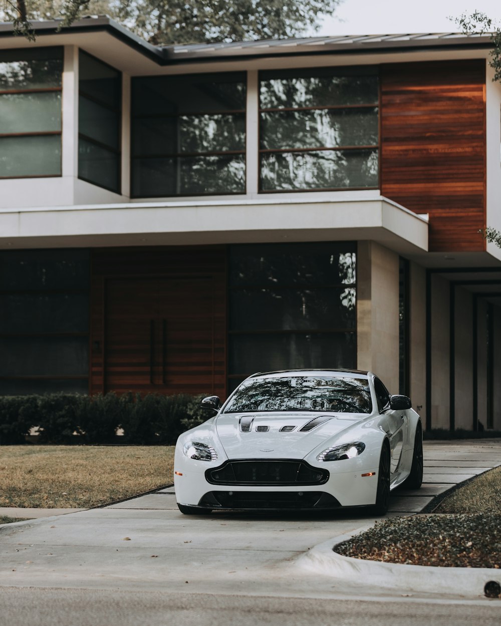 white coupe parked outside house