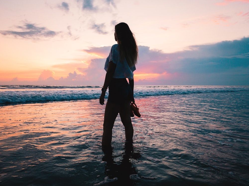 woman in white shirt and shorts on sea water